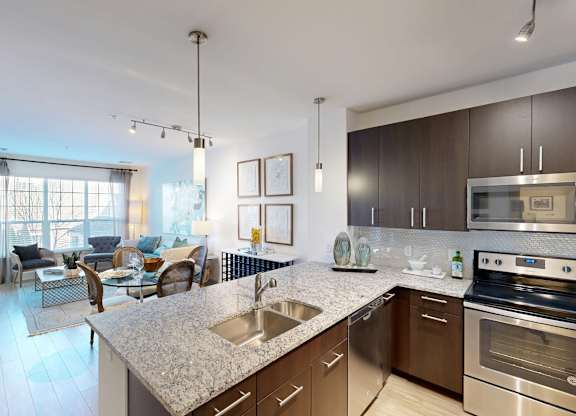 A modern kitchen with stainless steel appliances and a marble countertop.