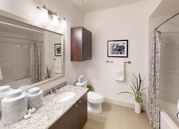 A bathroom with a white toilet, sink, and a shower curtain.