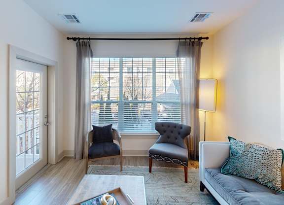 A living room with a grey couch, two chairs, and a coffee table.