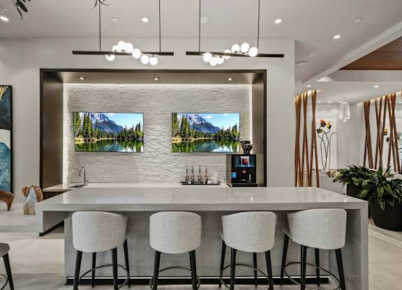 A modern kitchen with a bar area and a view of a mountain landscape on the wall.