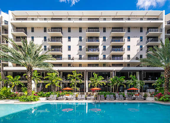 A large white building with a pool in front.