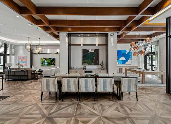 A modern dining room with a large table and chairs.