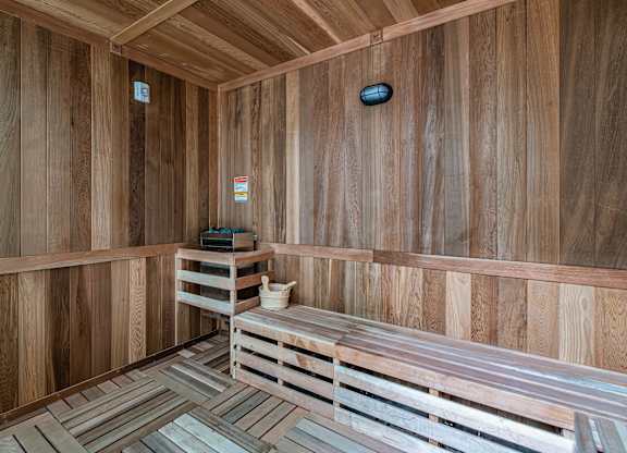 A wooden sauna with benches and a heater.