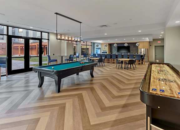A billiards room with a pool table and a shuffleboard table.