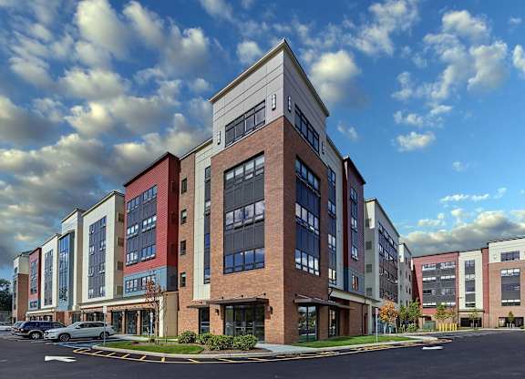 A large multi-story building with a parking lot in front.