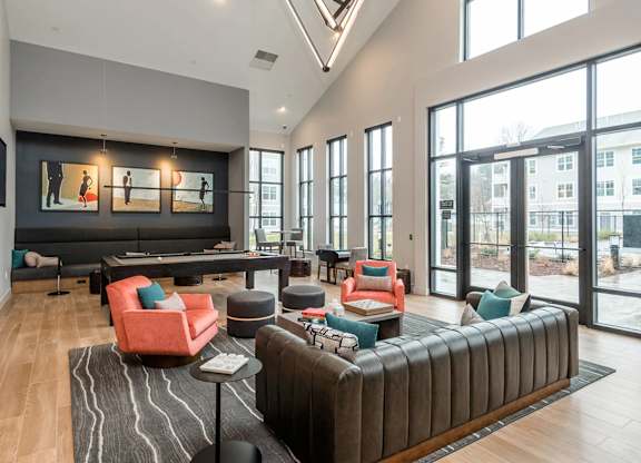 A spacious living room with a large sectional sofa and a long table with chairs.