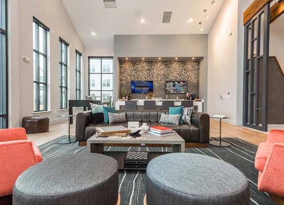 A modern living room with a grey sofa, a coffee table, and a TV mounted on the wall.