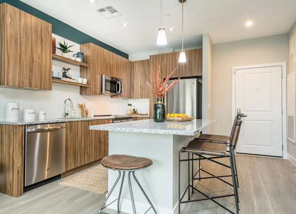 A kitchen with a white countertop and wooden cabinets.