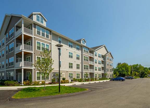 A large apartment complex with a parking lot in front.