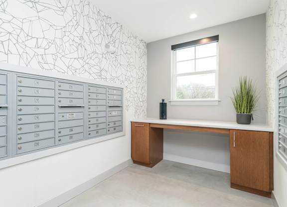A room with a desk, drawers, and a window.