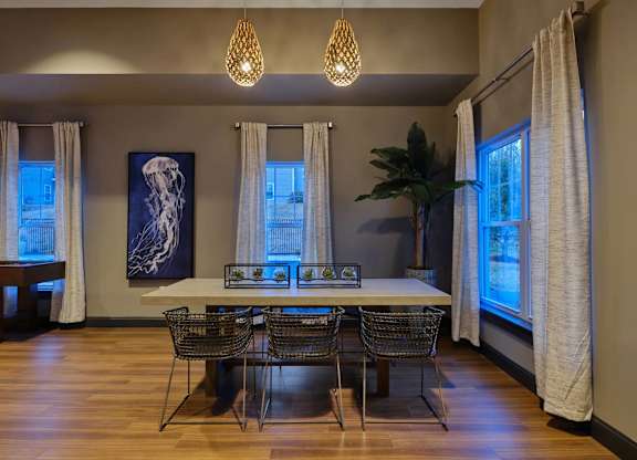 A dining room with a table and chairs.