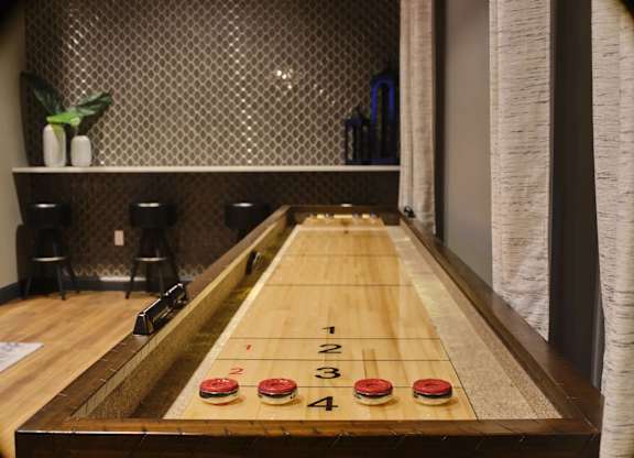 A shiny wooden table with four red buttons and numbers 1 to 4 on it.