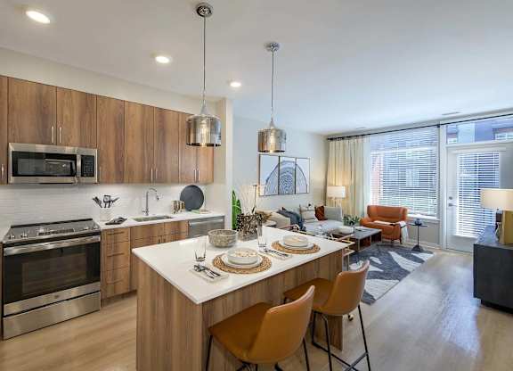 A modern kitchen with wooden cabinets and a large island.