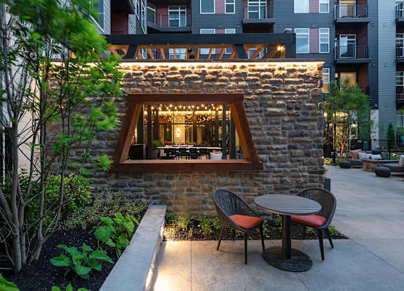 A small stone building with a window and lights on it.