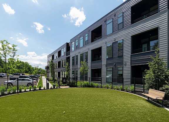 A modern building with a grassy area in front.