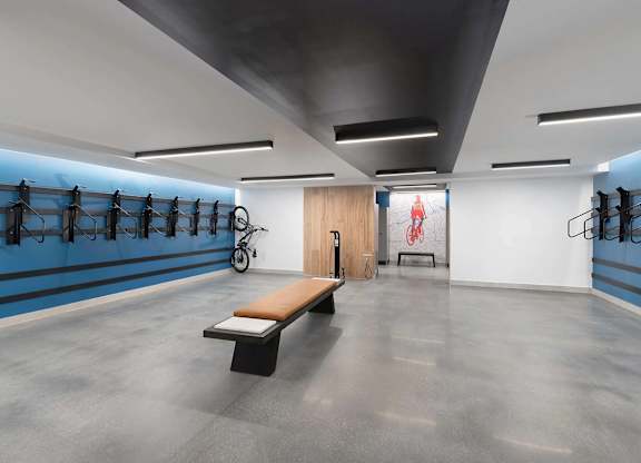 A gym with a bench, a bicycle, and racks of equipment.