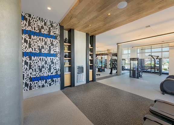 A gym with a motivational wall and exercise equipment.