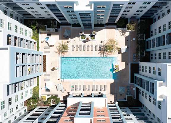A swimming pool is surrounded by buildings.