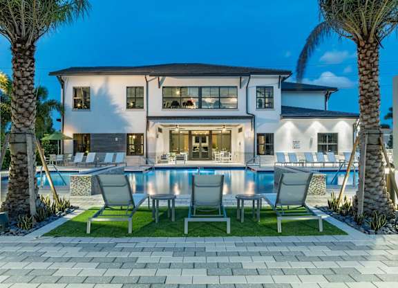 A modern house with a pool and palm trees.