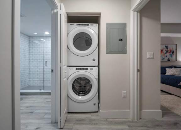 A white front loading washing machine is in a doorway.