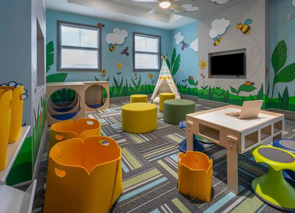 A child's playroom with a wooden table and yellow chairs.
