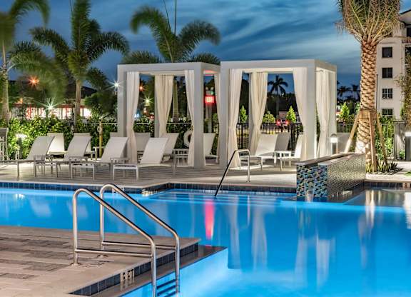 A pool with a staircase and a white canopy.
