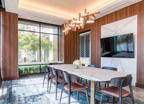A dining room with a large table and chairs.