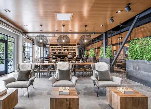 A modern living room with a wooden ceiling and grey chairs.