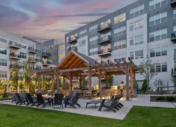 A modern apartment complex with a communal outdoor seating area.