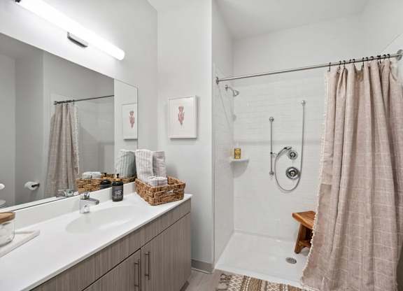 A bathroom with a white sink, a white tub, and a brown shower curtain.