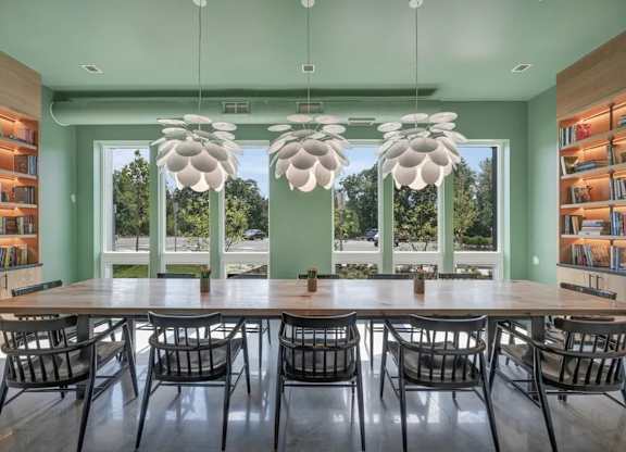 A dining room with a long table and chairs.