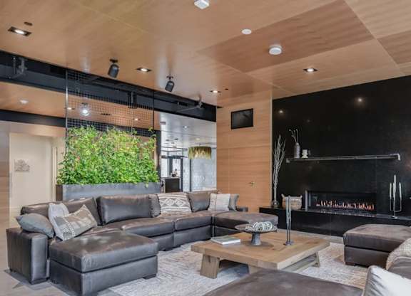 A modern living room with a black fireplace and a large grey sofa.