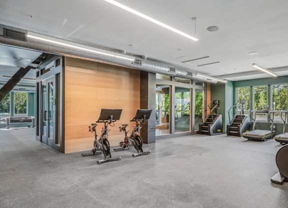A gym with a variety of equipment including treadmills, stationary bikes, and weight machines.