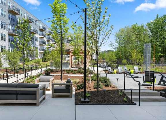 A modern outdoor seating area with benches and trees.