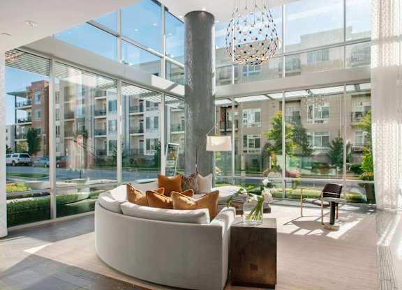 A modern living room with a large white couch and a tall column.