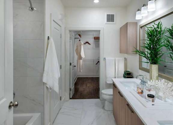A bathroom with a white tub and a white sink.