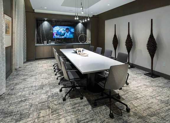 A conference room with a long table and chairs.