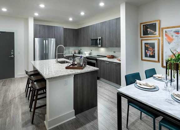 A modern kitchen with a white island and dark wood cabinets.