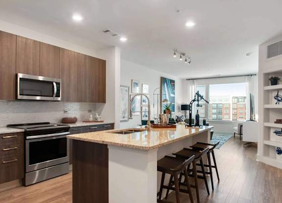 A modern kitchen with a large island and wooden cabinets.