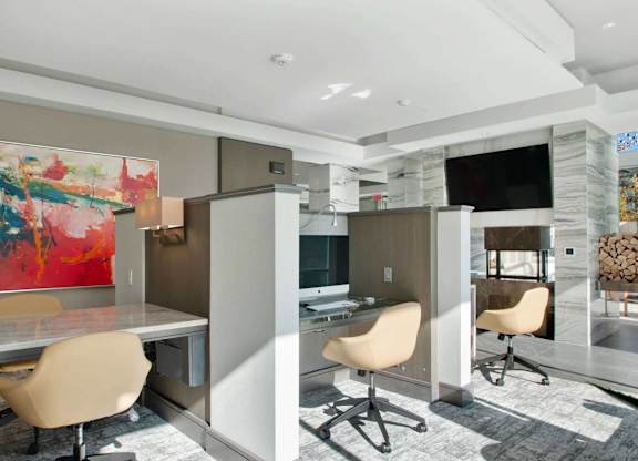A modern office space with a large painting on the wall and a TV in the corner.