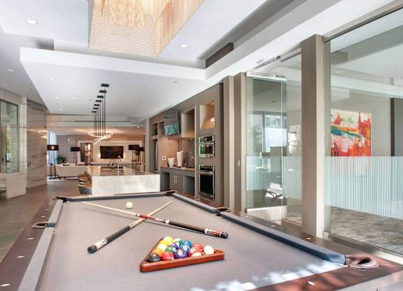A pool table in a room with a glass wall.