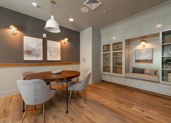 A dining room with a wooden table and grey chairs.