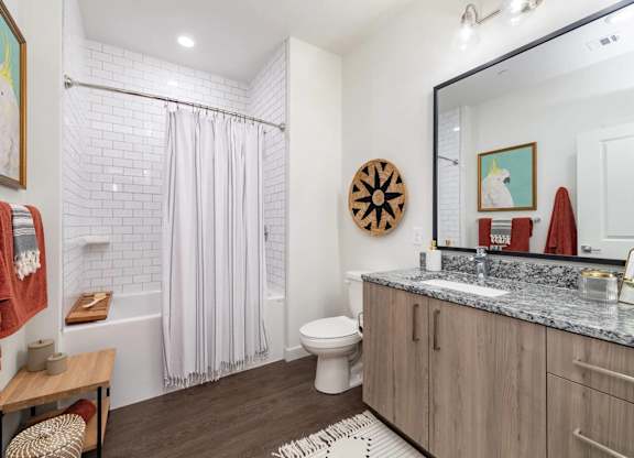 A bathroom with a toilet, sink, and shower.