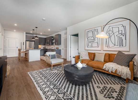 A living room with a couch, coffee table, and a rug.