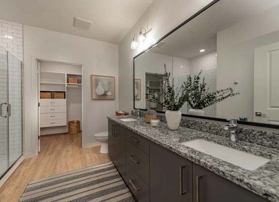 A bathroom with a marble countertop and a large mirror.