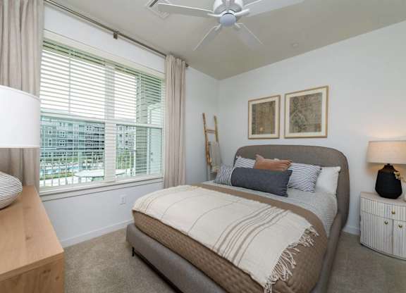 A bedroom with a large bed and a ceiling fan.