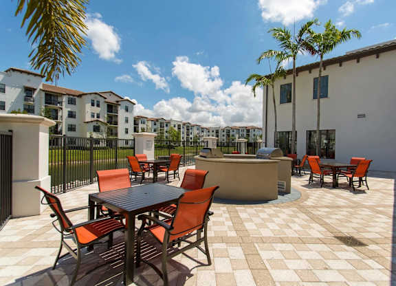 A patio with a table and chairs is surrounded by buildings.