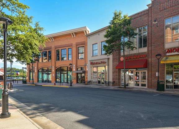 A street view of a shopping area with a clear blue sky.