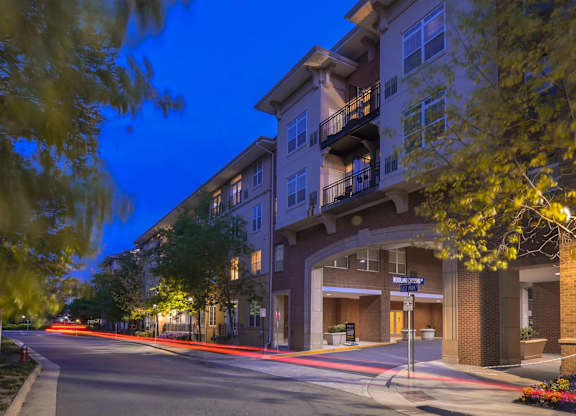 A street view of a residential area with apartment buildings and a street sign.