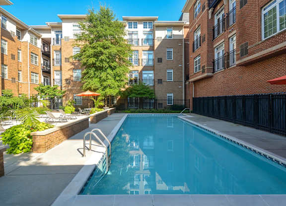 A swimming pool in a courtyard surrounded by buildings.